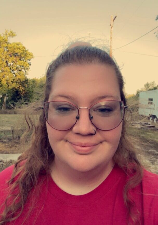 A woman with glasses is smiling for the camera.